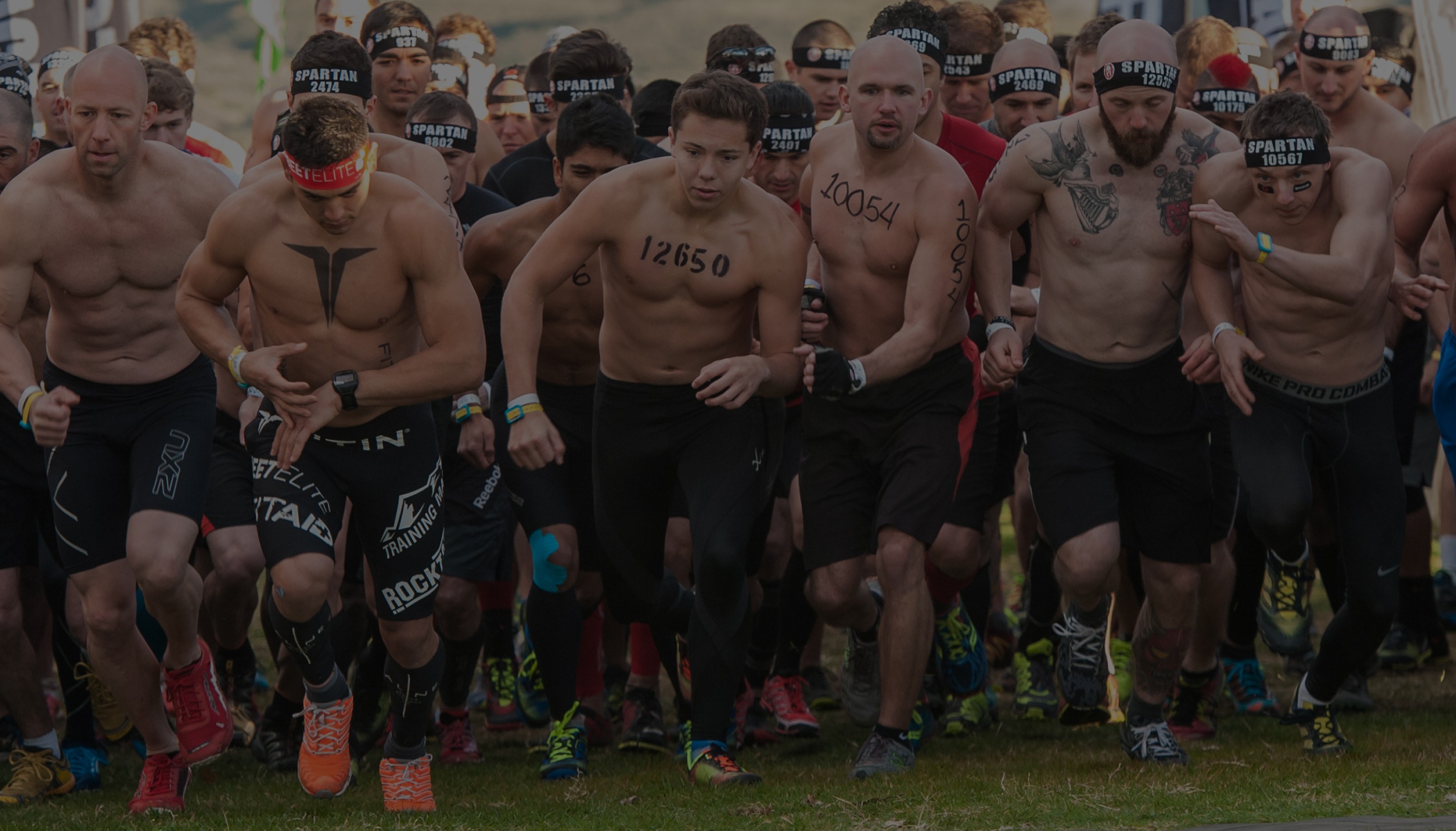 Baclground photo of a large group of Spartan Racers leaving leaving the starting line