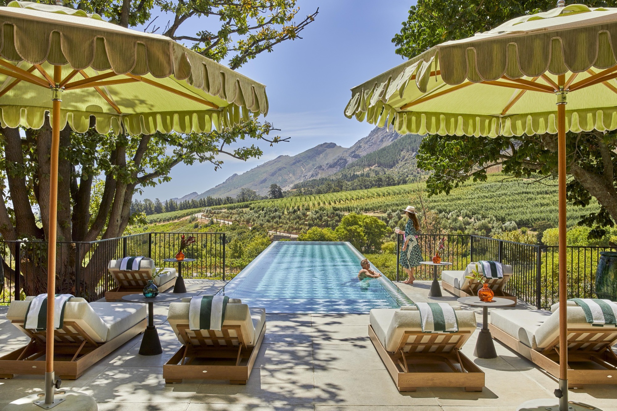 A family afternoon at a fringed-umbrella pool above the vines