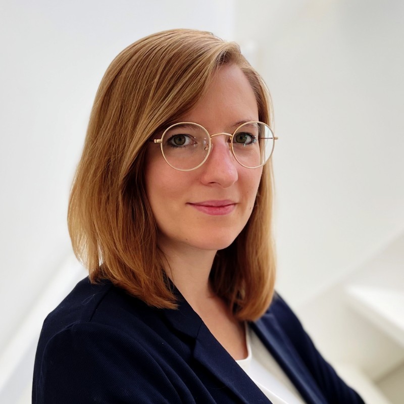 Portrait von Dr. Maren Diether, lächelnd, mit Brille, vor hellem Hintergrund.