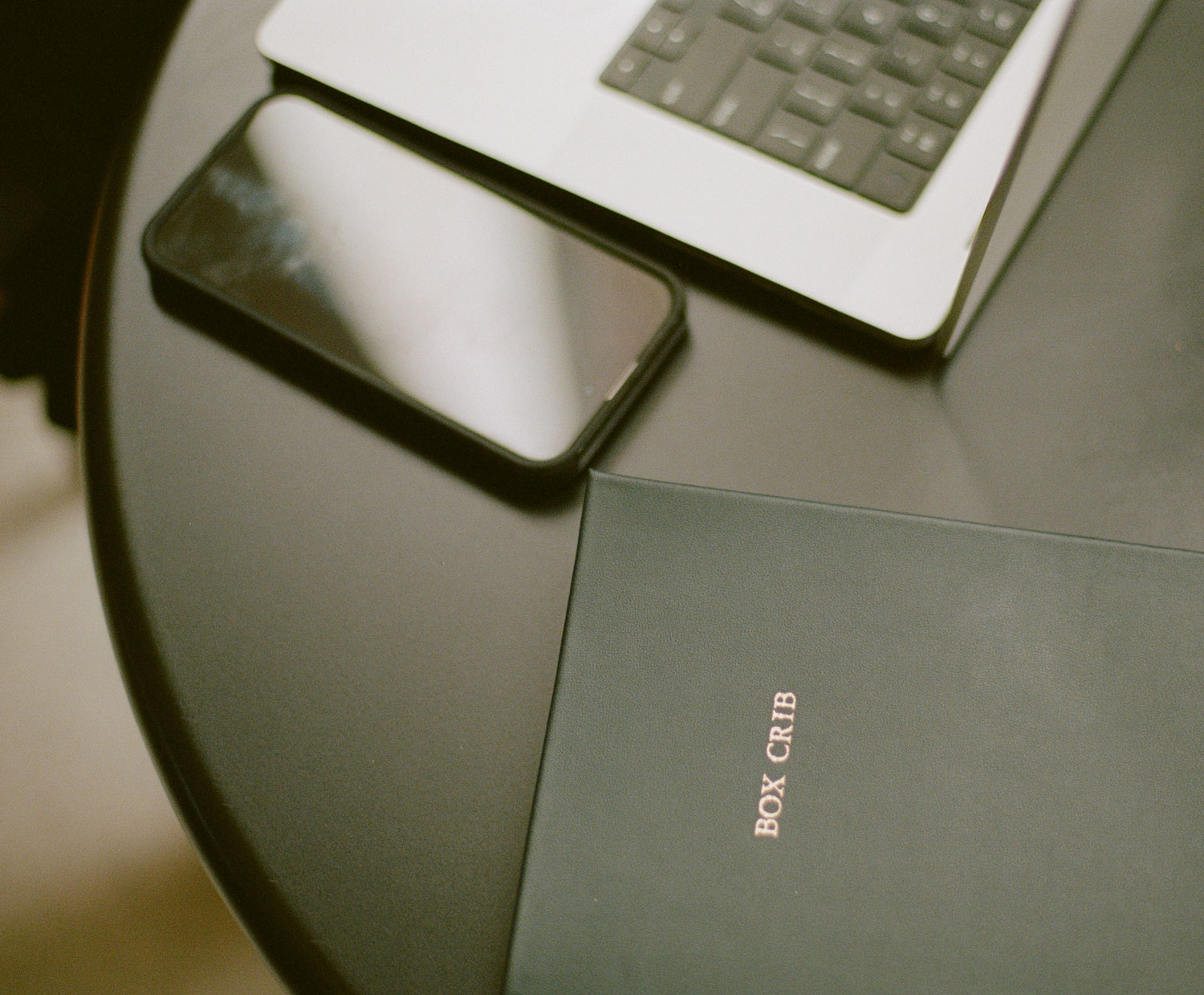 Two people focus on a laptop screen in a collaborative office setting. 