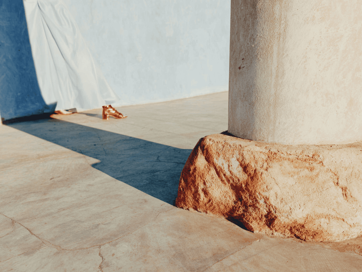 Stone column base on a tiled floor with draped white fabric