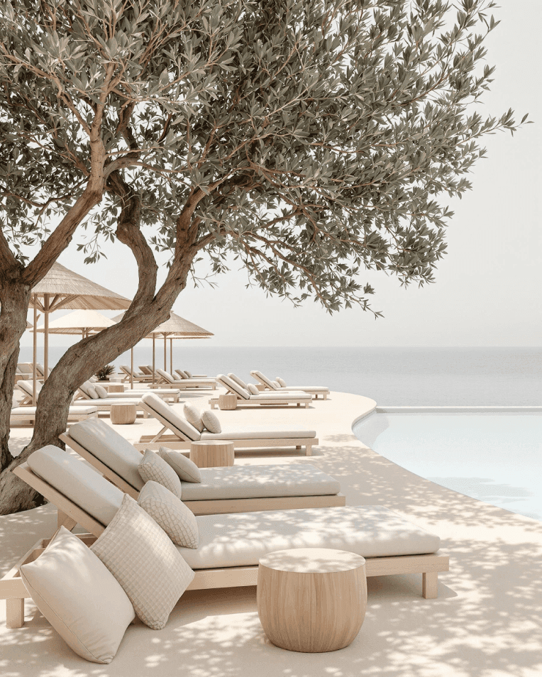 Tranquil poolside loungers under tree shade with ocean view in the background.