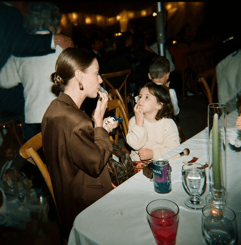 Photojournalistic wedding shot of a mother and daughter enjoying a quiet snack together, portraying the natural, intimate moments often highlighted in documentary-style photography.