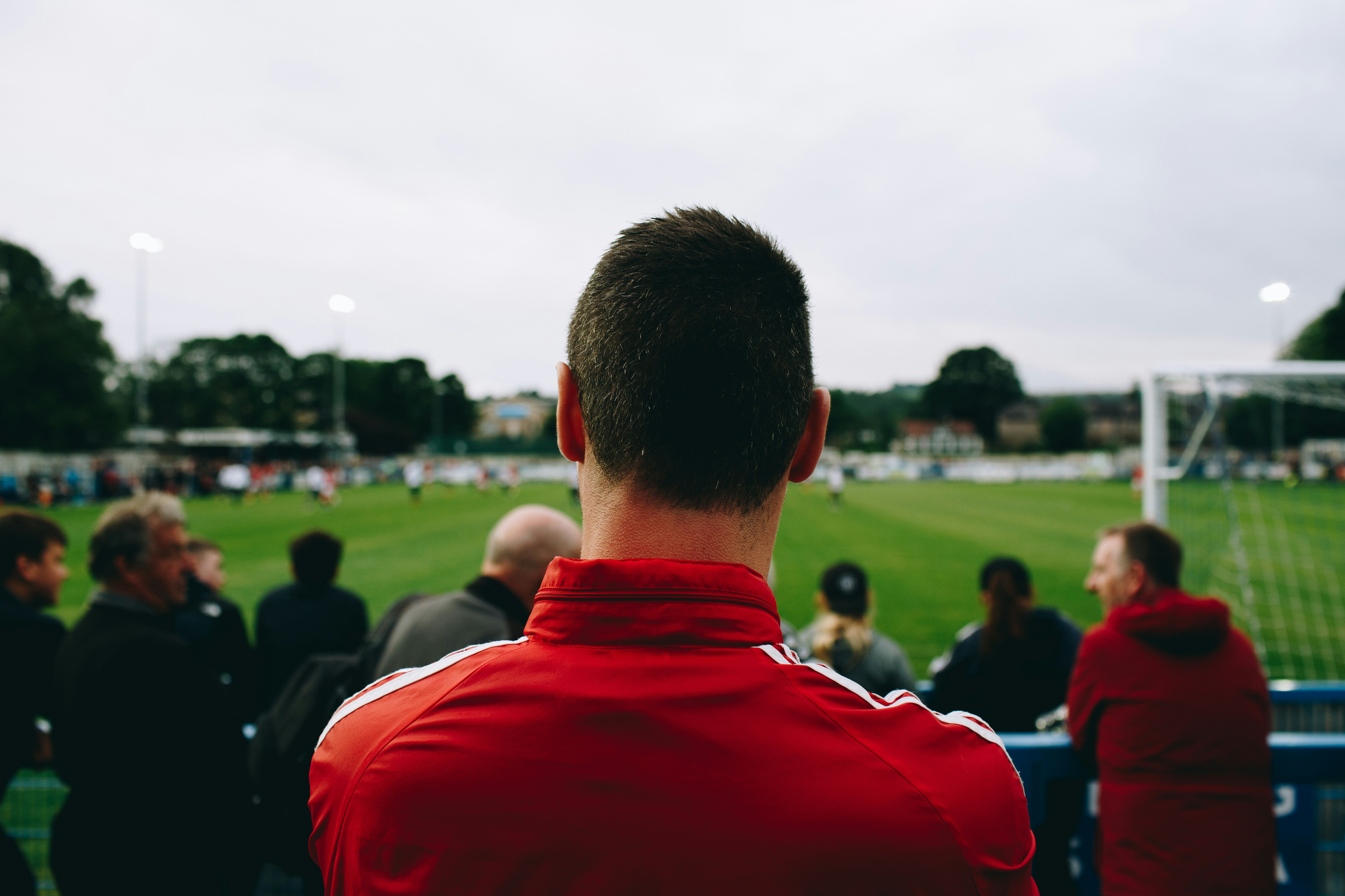 A picture of a man with his friends on the soccer pitch to represent how it feels to be a part of an online betting community.