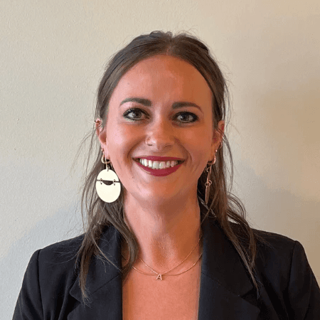 A headshot of a smiling client against an office wall.