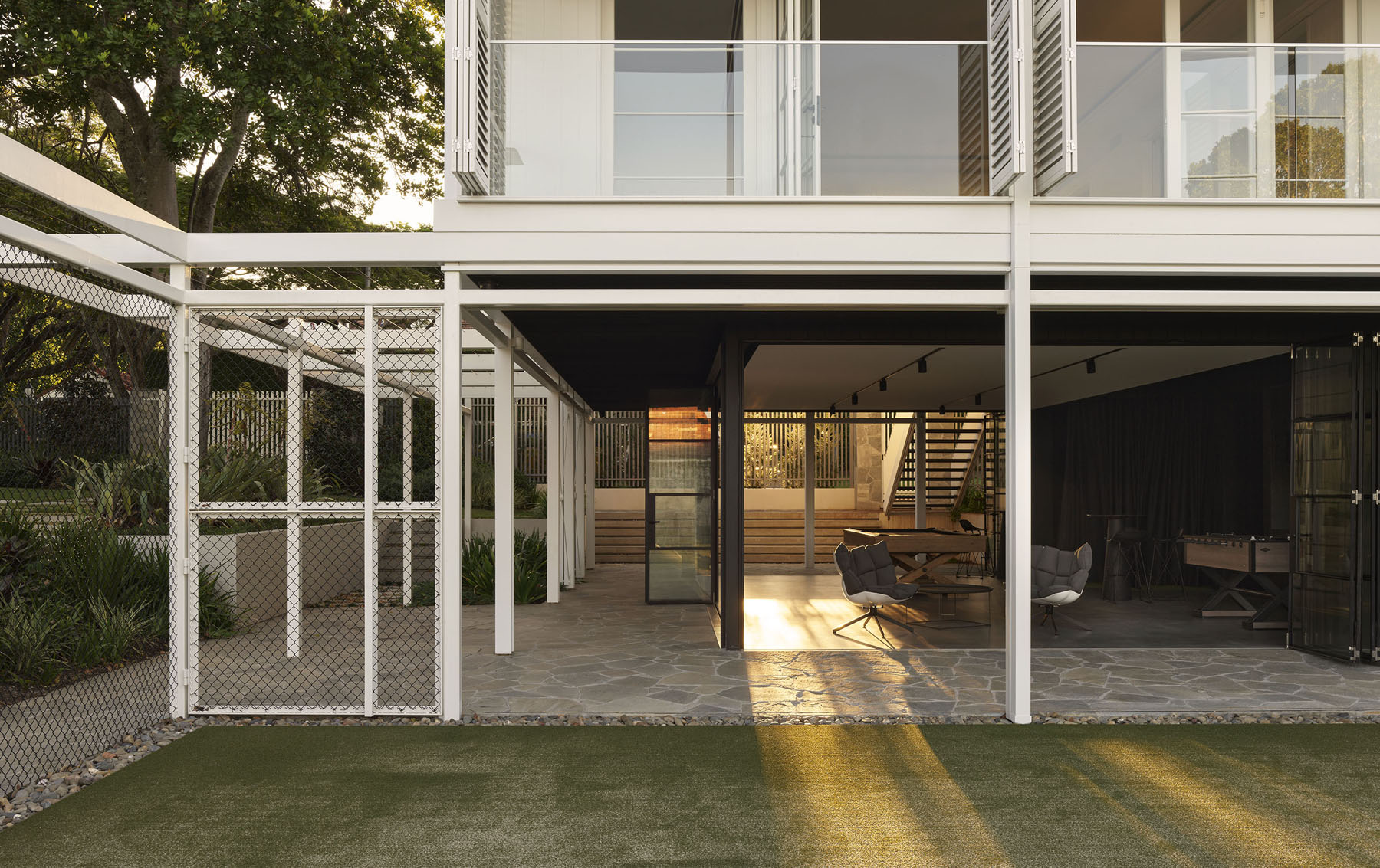 ground level outdoor living space beneath elevated pavilion with open structure