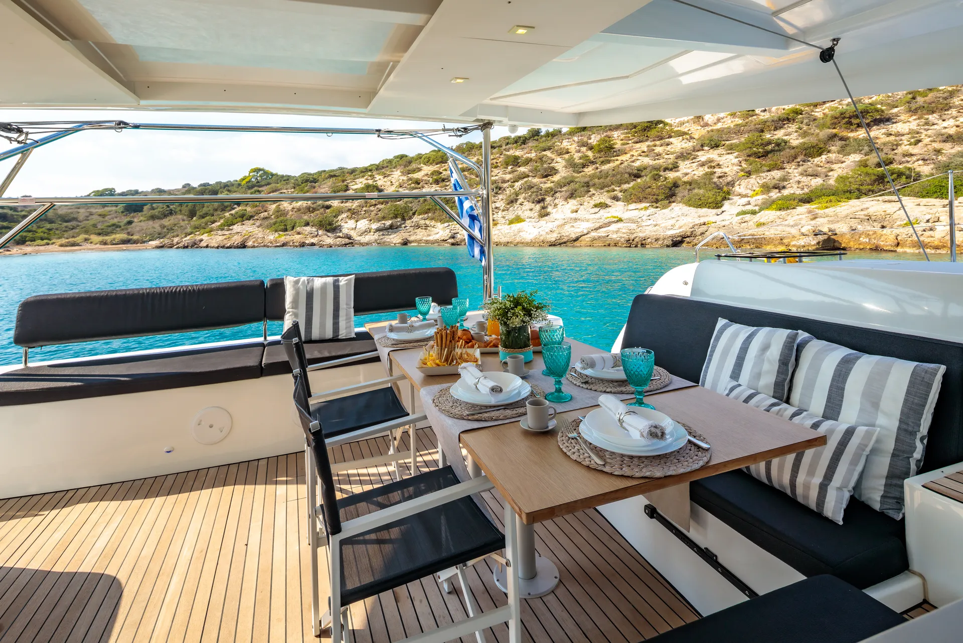 White Rock 36 speedboat with captain at helm cruising calm blue waters near Paros coastline with hills in background.