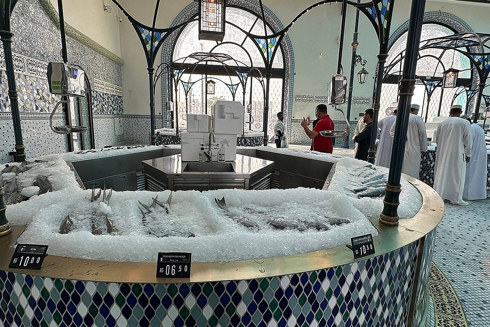 Un étal de poissons frais sur glace dans un marché couvert, comme on en trouve sur les étals du Qatar