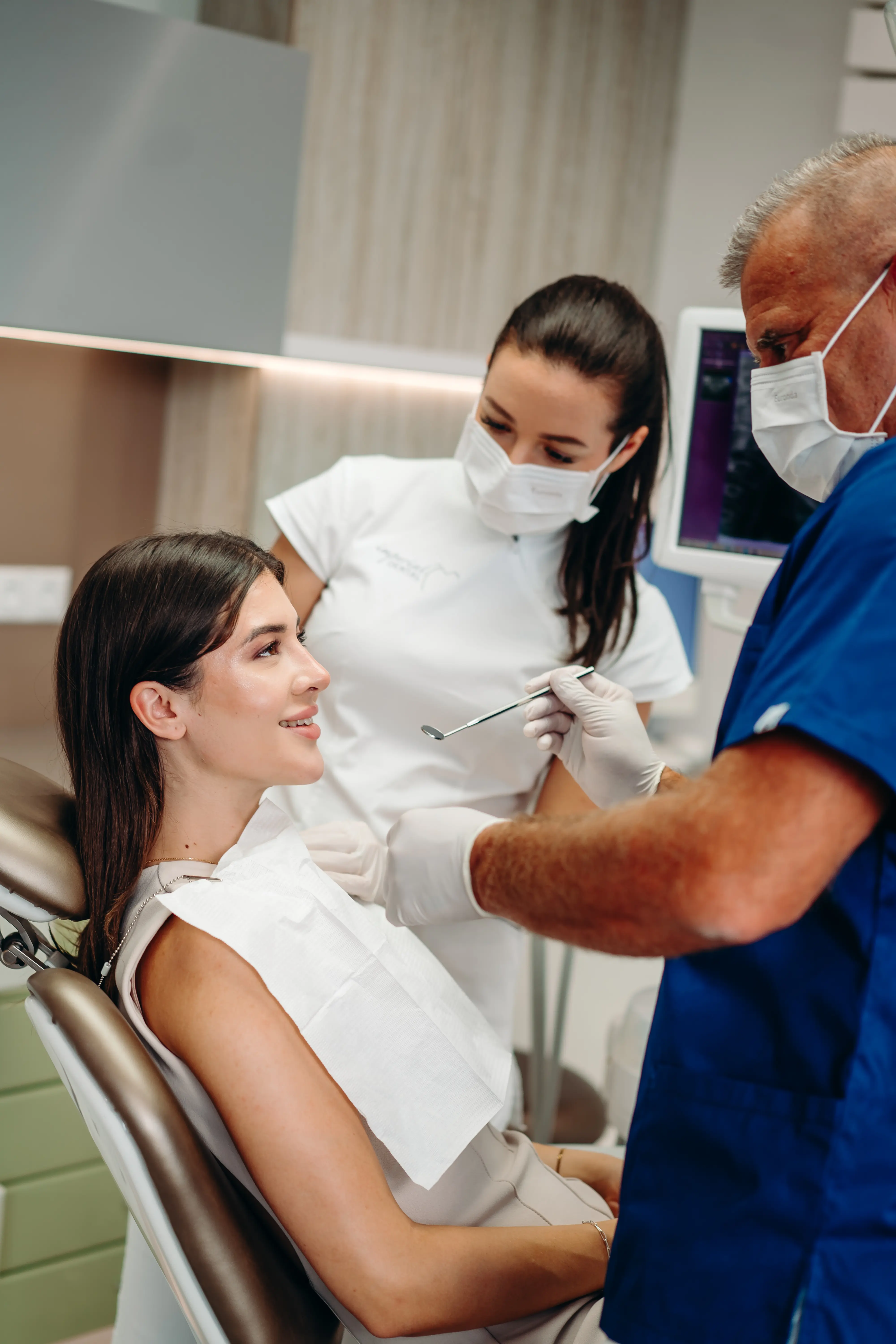 Fogorvos pácienssel konzultál, miközben fogröntgent néznek a képernyőn.