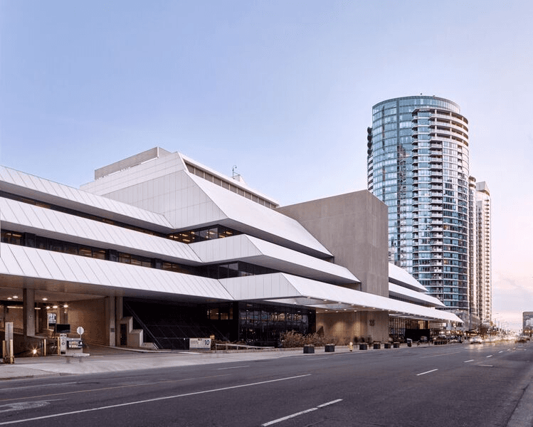 Restored brick building with arched windows and modern glass storefront on a quiet street