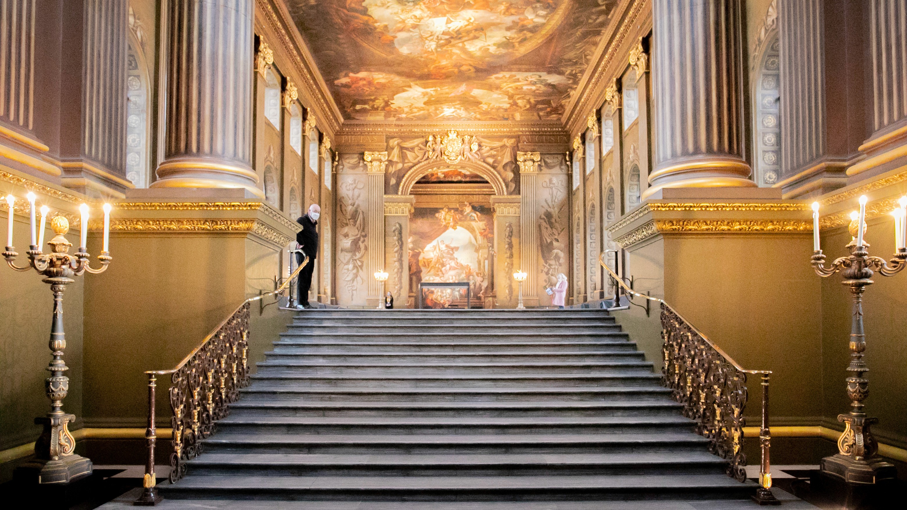 Two classic volkswagen beetles, one green, one cream.