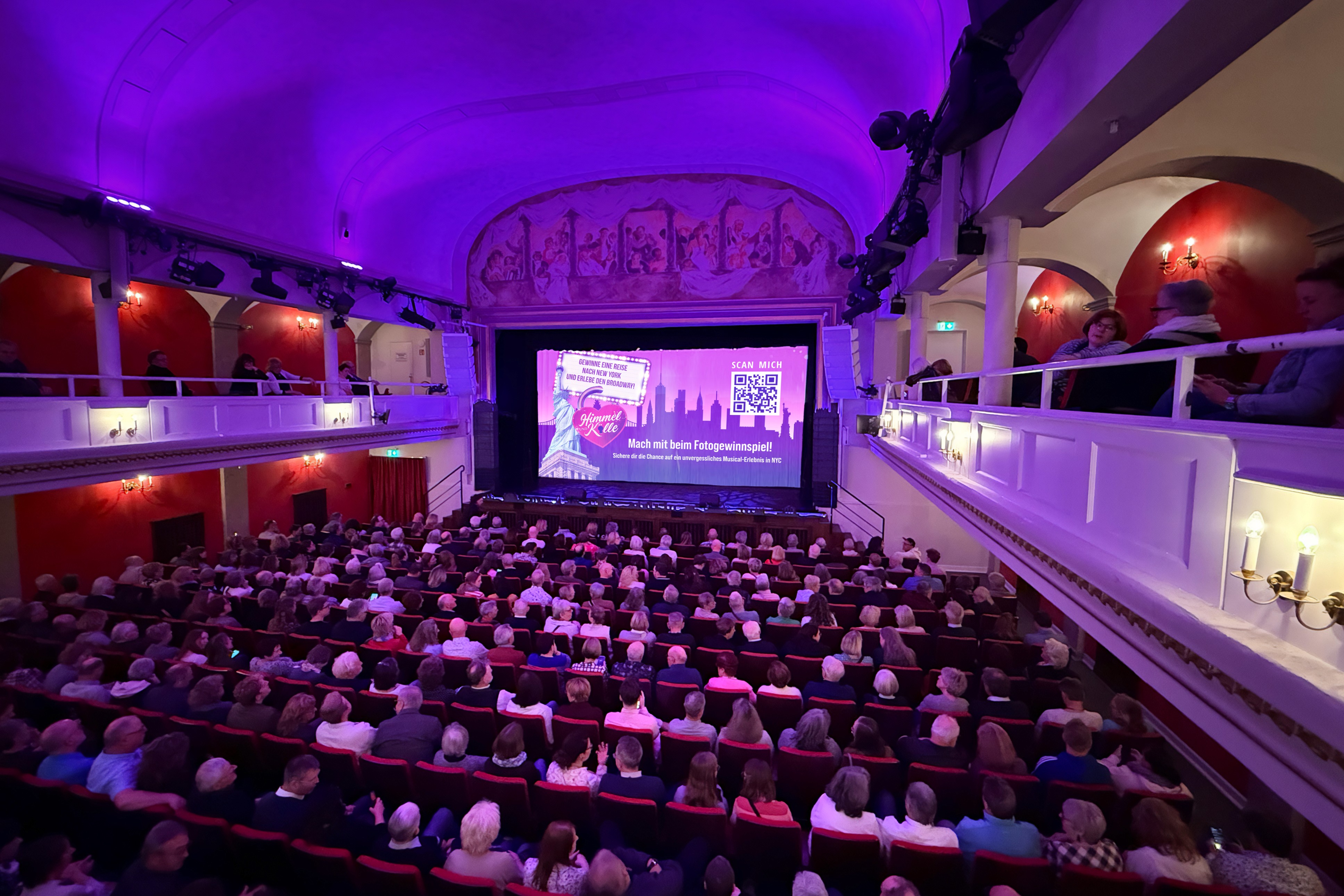 Publikum vor Leinwein mit QR Code für Gewinnspielteilnahme