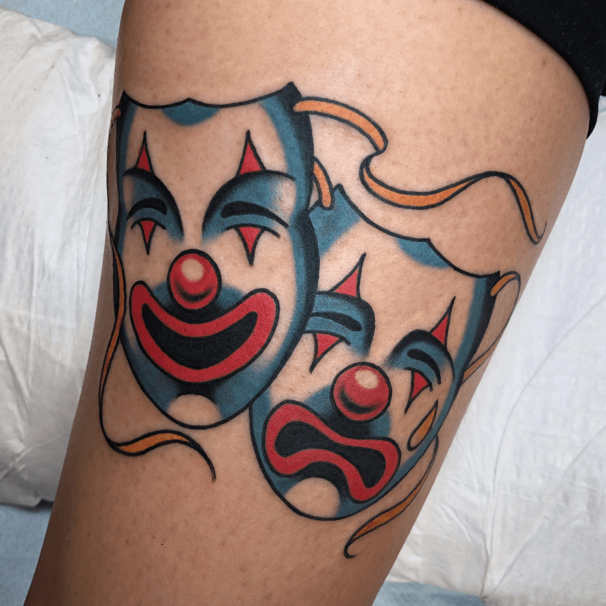 color tattoo of a laugh now, cry later masks