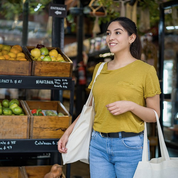 Woman carrying reusable bags at the market.