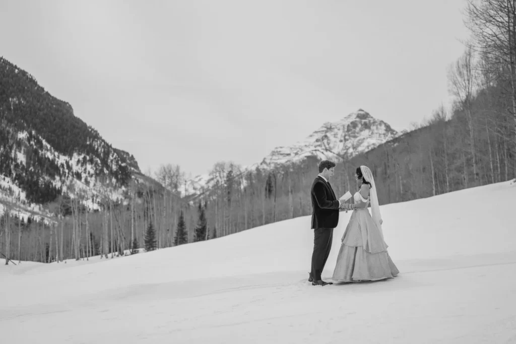 Wide shot couple in snowy field during T-Lazy 7 elopement Aspen Colorado
