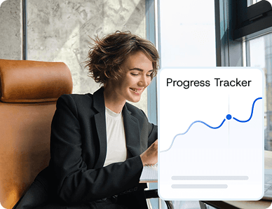 Businesswoman smiling at her desk with a screen showing a rising progress chart titled “Progress Tracker,” representing live operational visibility.