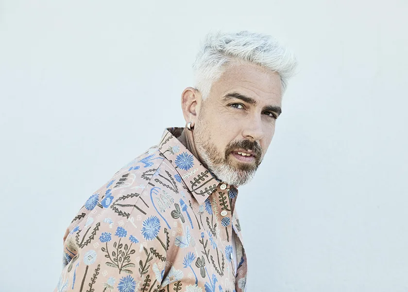 A man, singer and artist, looking at you