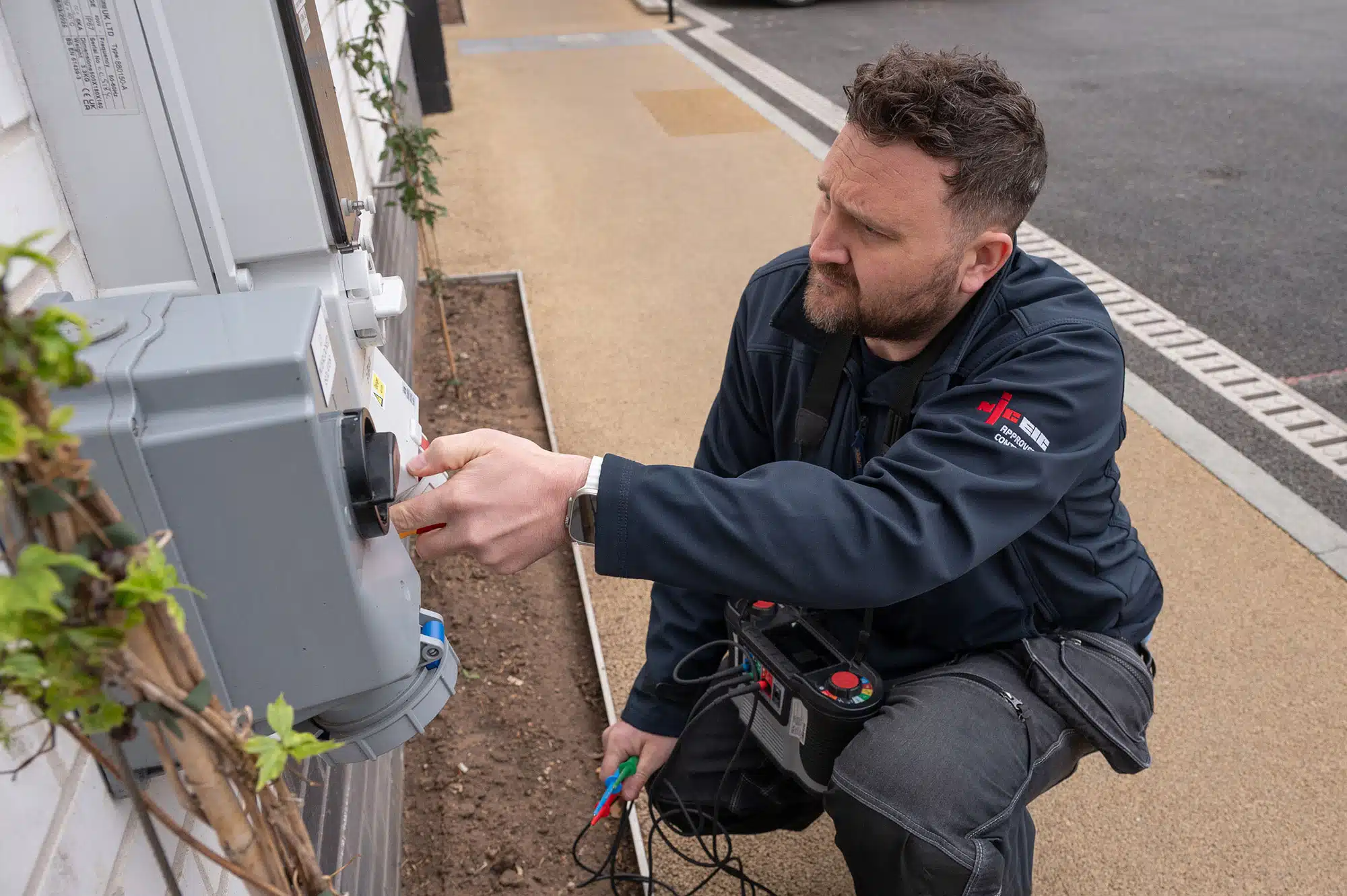 Two electricians inspecting circuit breaker panel wiring during residential electrical repair