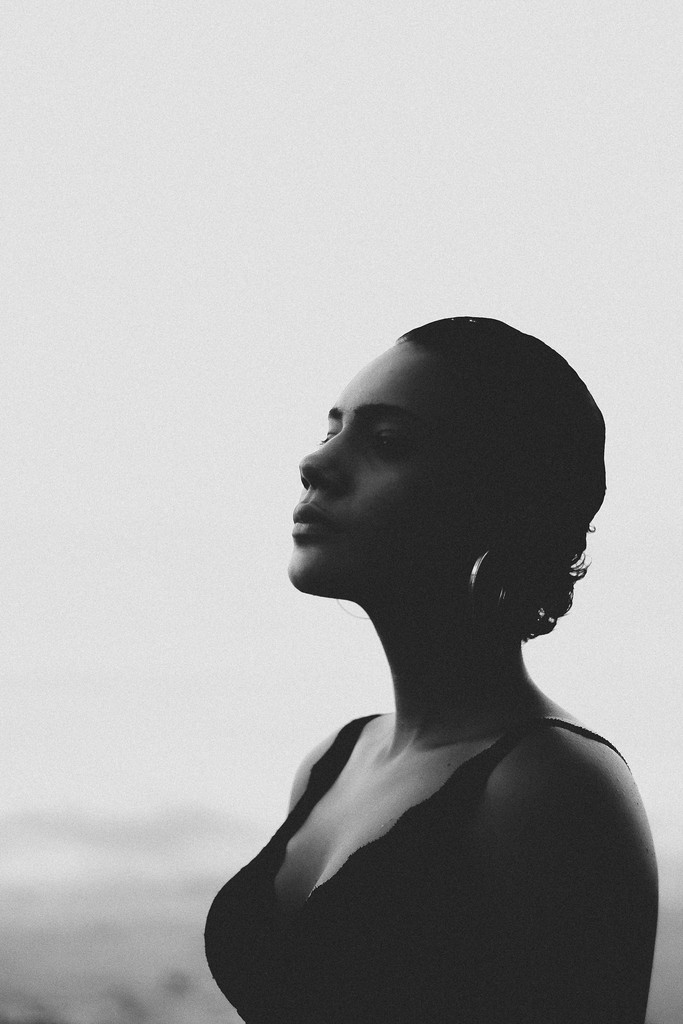 black white portrait of a woman with closed eyes enjoying the breeze of air outside.