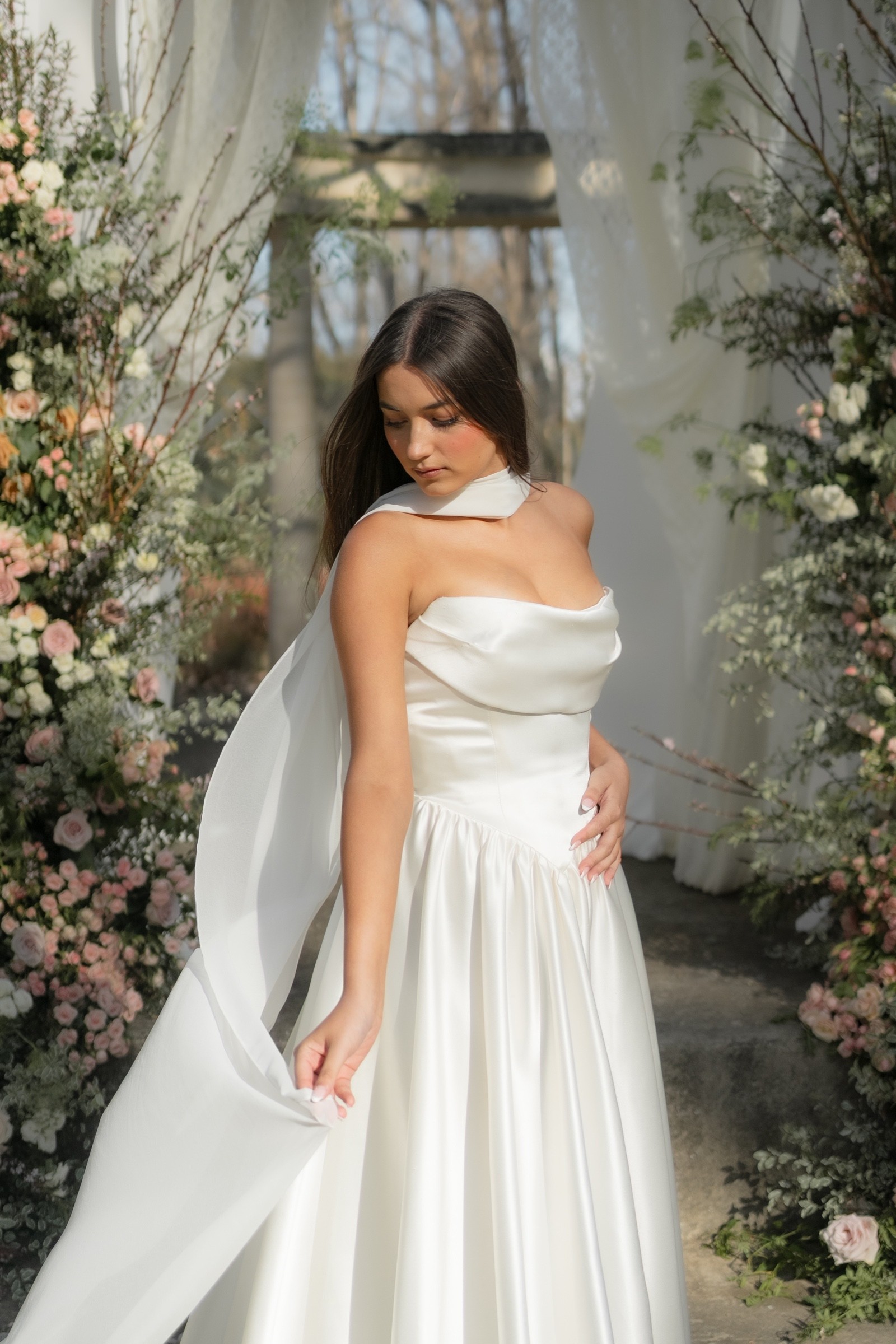 Bride in a satin gown framed by flowers and draping at the Mona Farm Rotunda