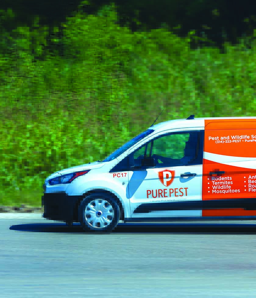 A Pure Pest vehicle driving to a job