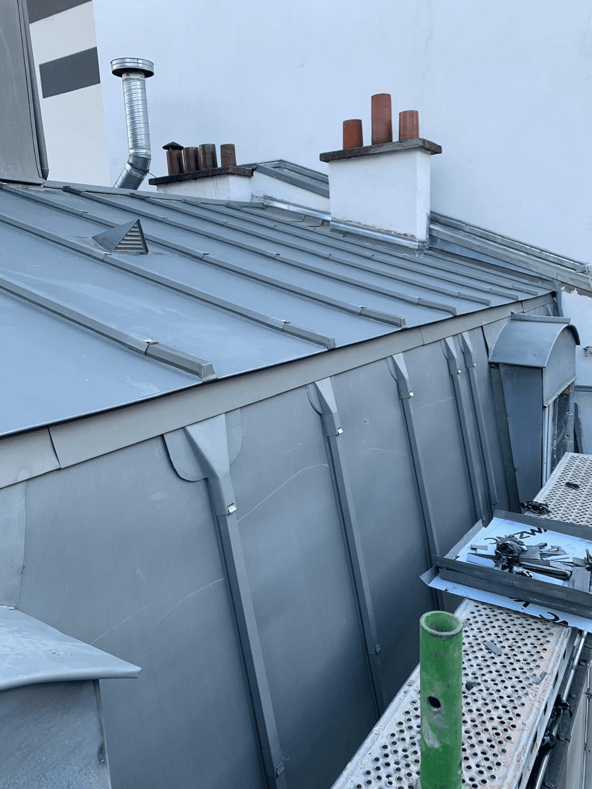 woman in blue jacket and blue denim jeans standing on brown wooden bridge