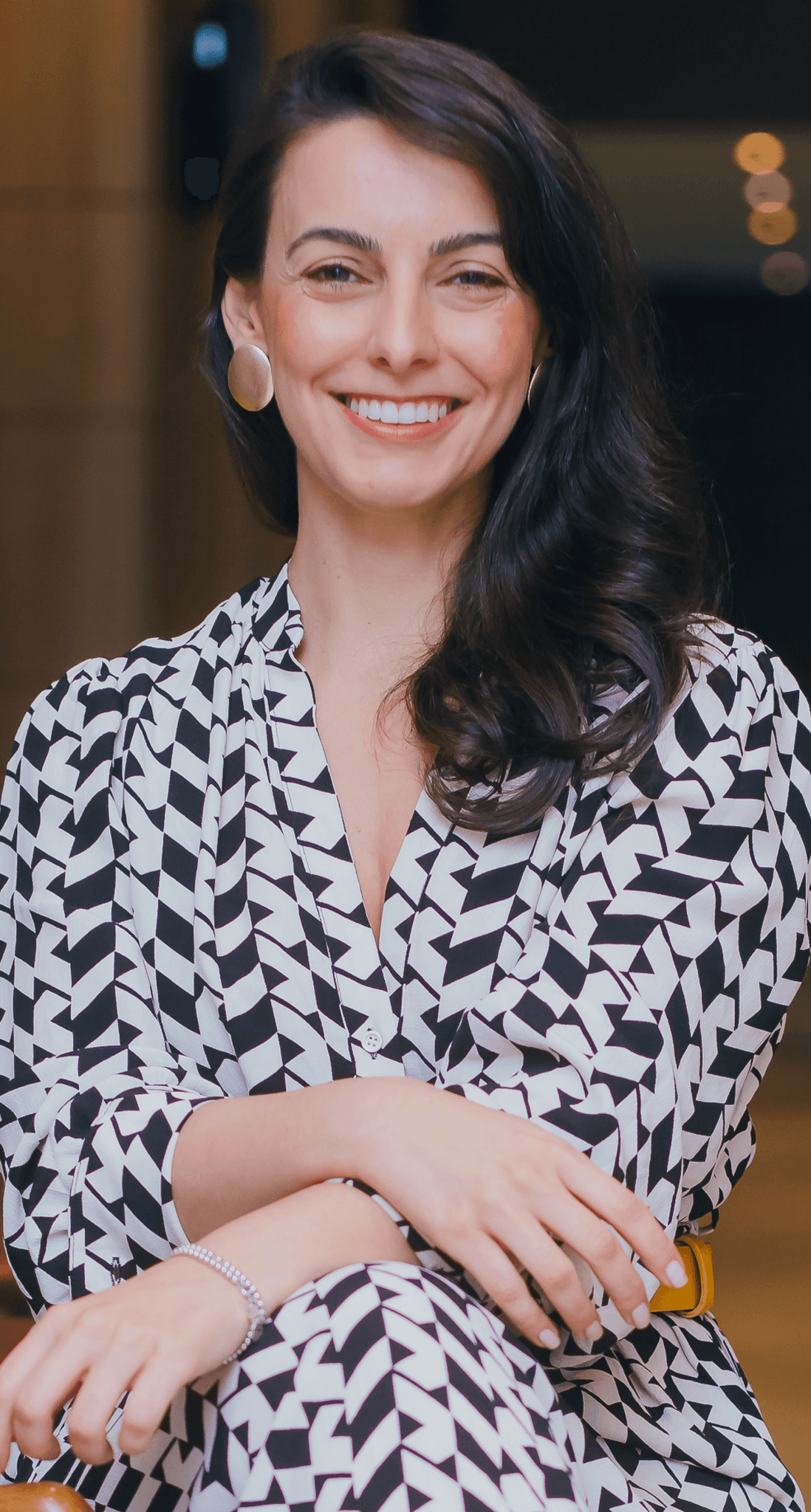 Juliana Casagrande sorrindo, usando roupa geométrica preta e branca
