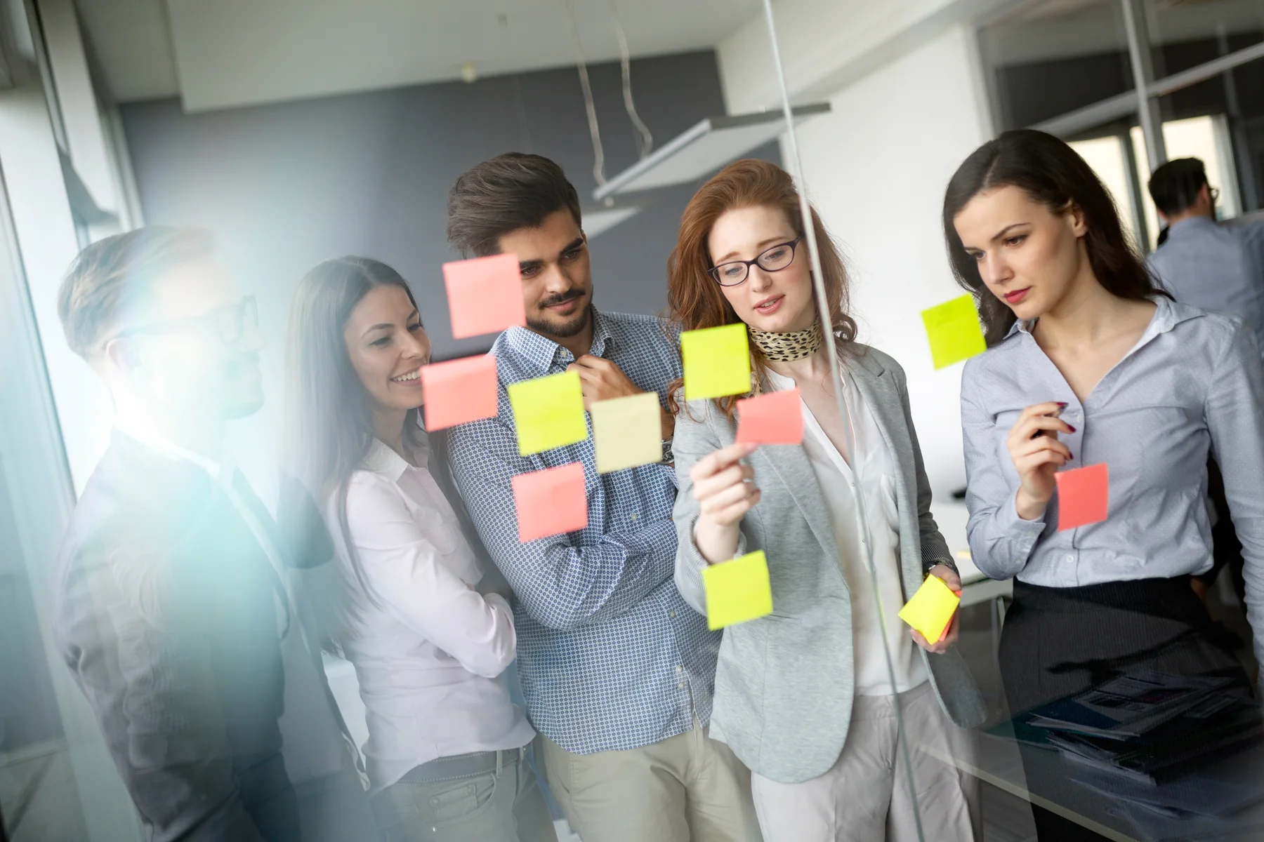 Team Collaborating on Sticky Notes in Modern Office