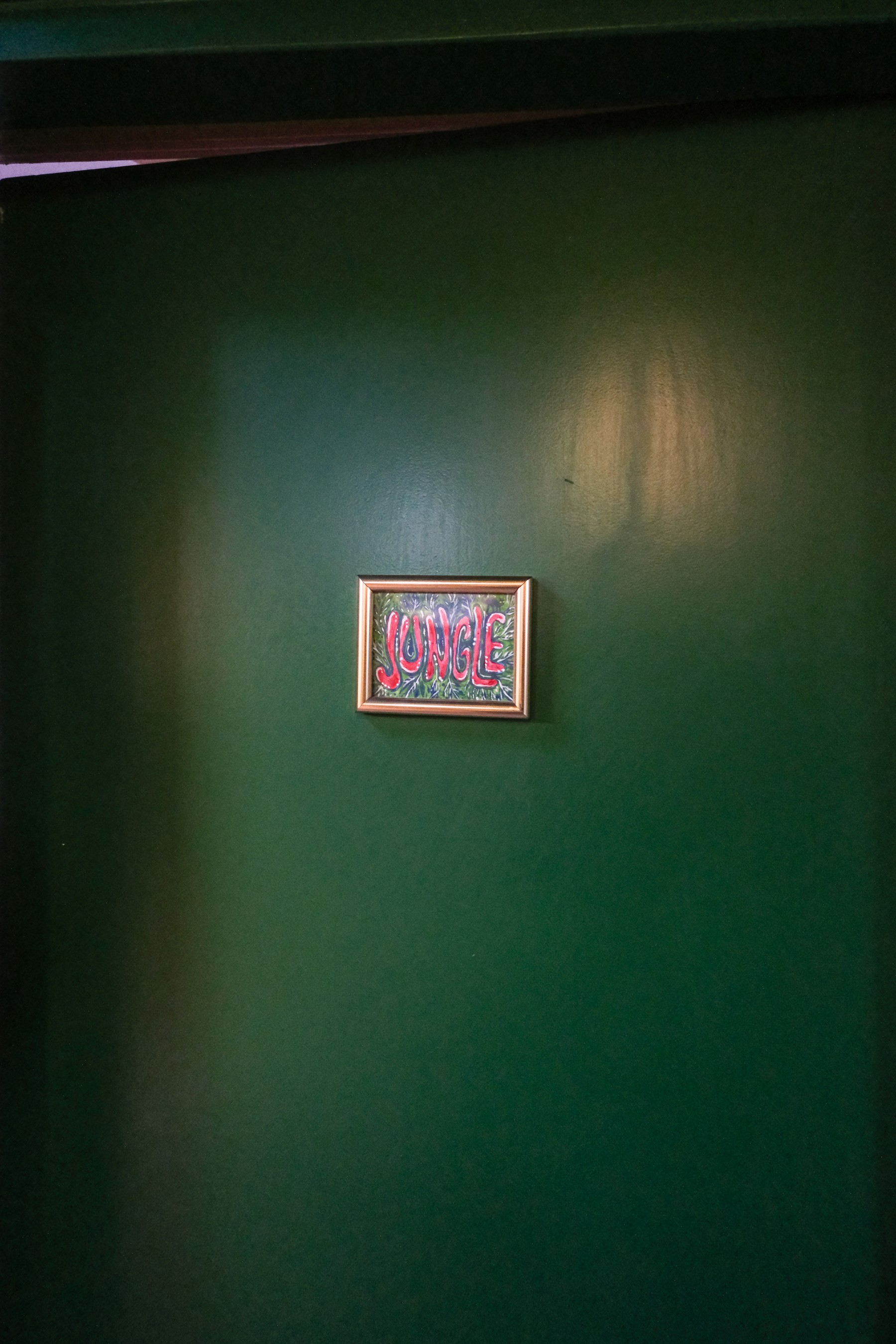 Beige upholstered bed with patterned pillows and ottomans