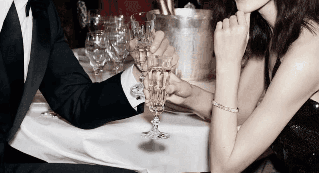 An elegant evening scene with two people in formal attire clinking champagne glasses, symbolizing sophistication and celebration.  