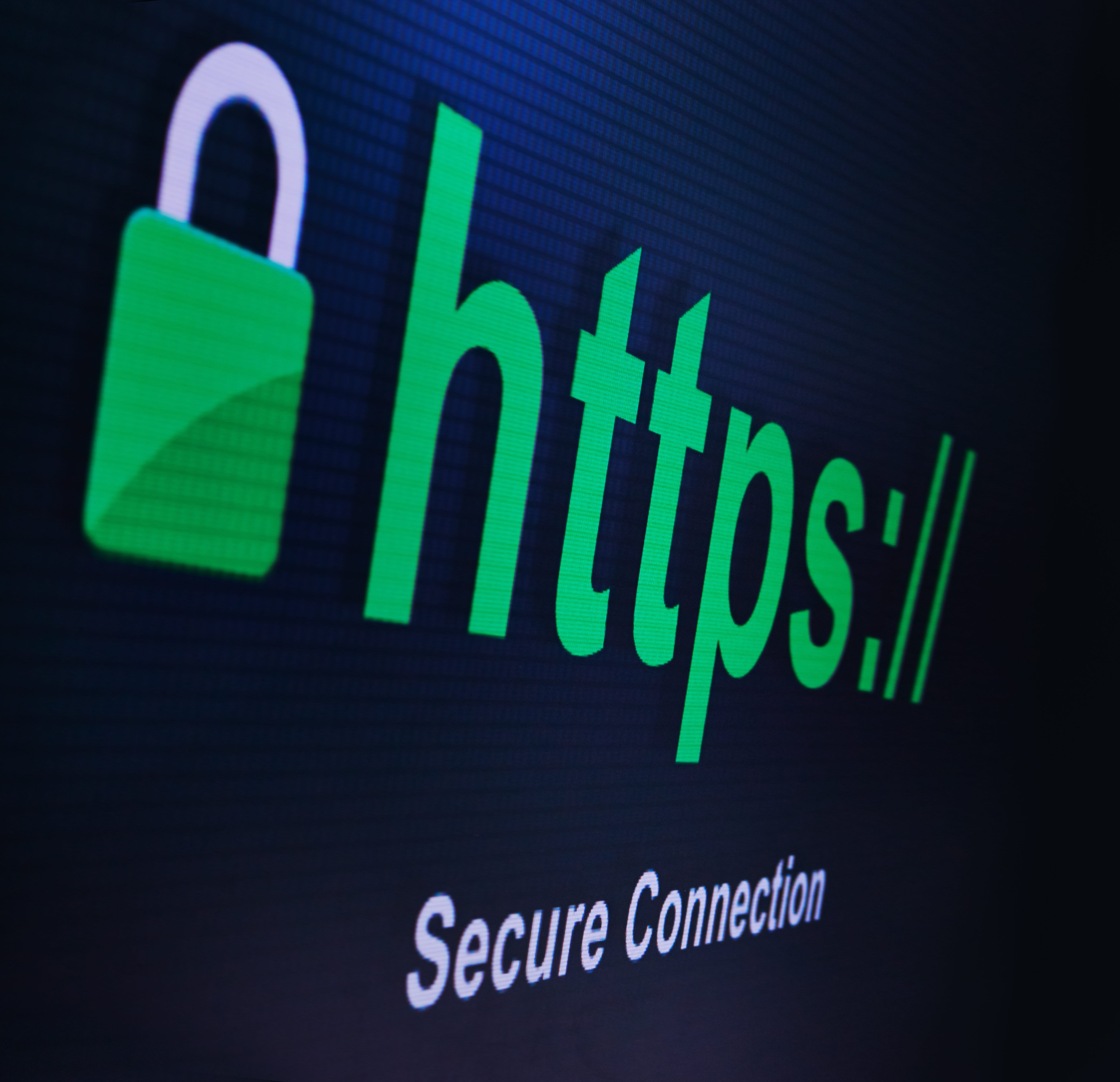 A close-up of a computer screen displaying a green padlock icon and "https://" text, symbolizing a secure connection for website security and data encryption.