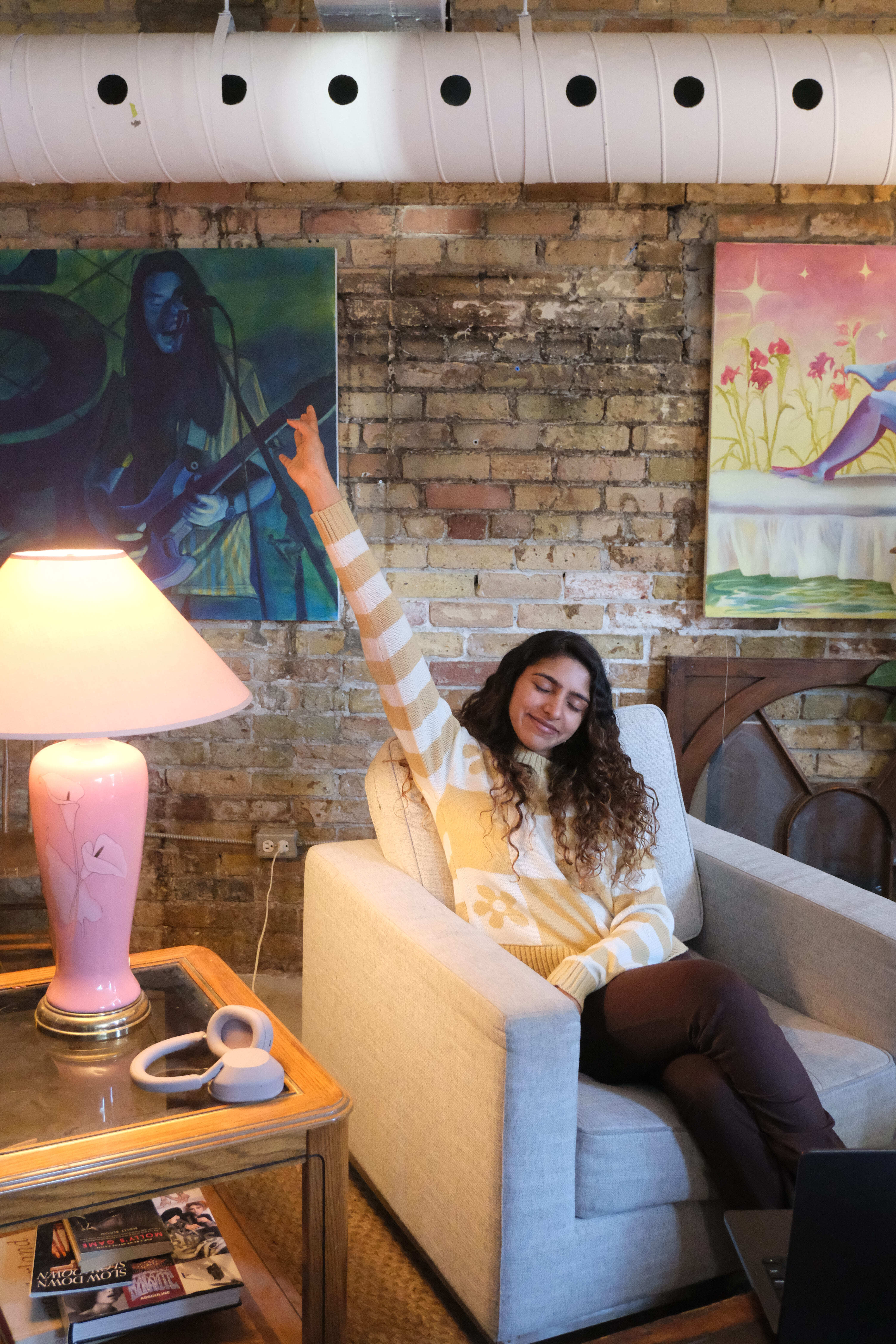 Creative brand strategist celebrating successful website launch in artistic studio workspace