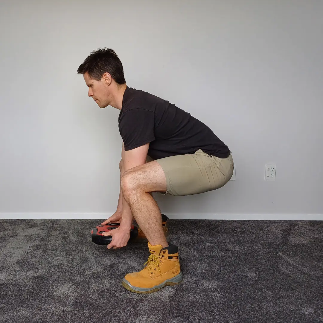 Physiotherapist showing correct lifting technique for construction workers