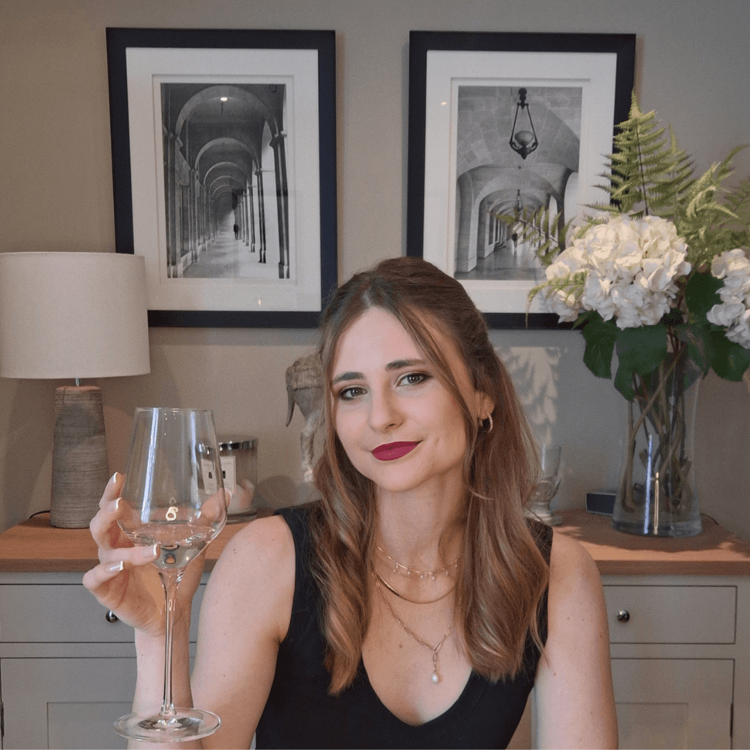 Co-founder Caitlin smiling with a wine glass