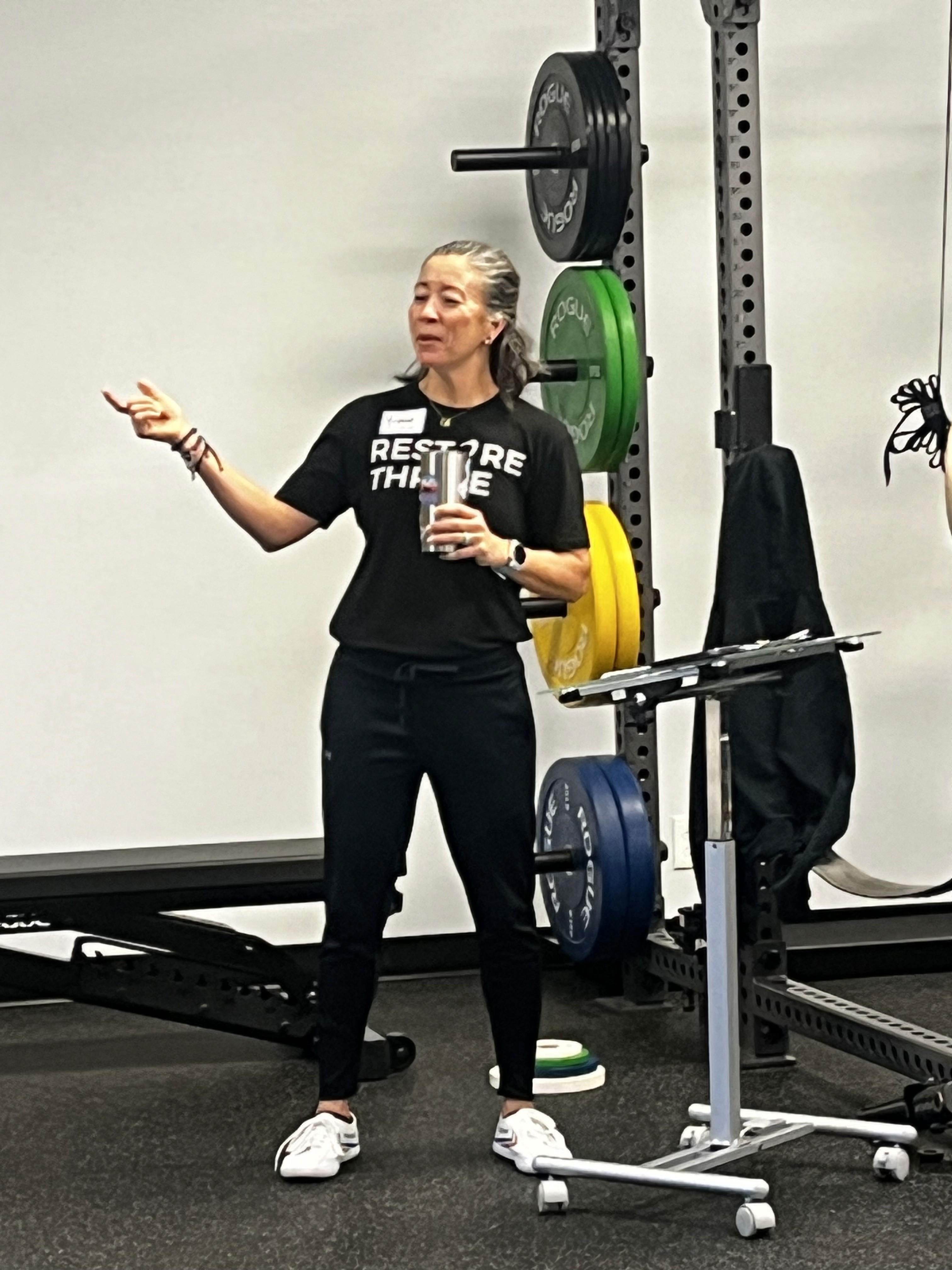 An athletic trainer coaching an athlete in a gym space.