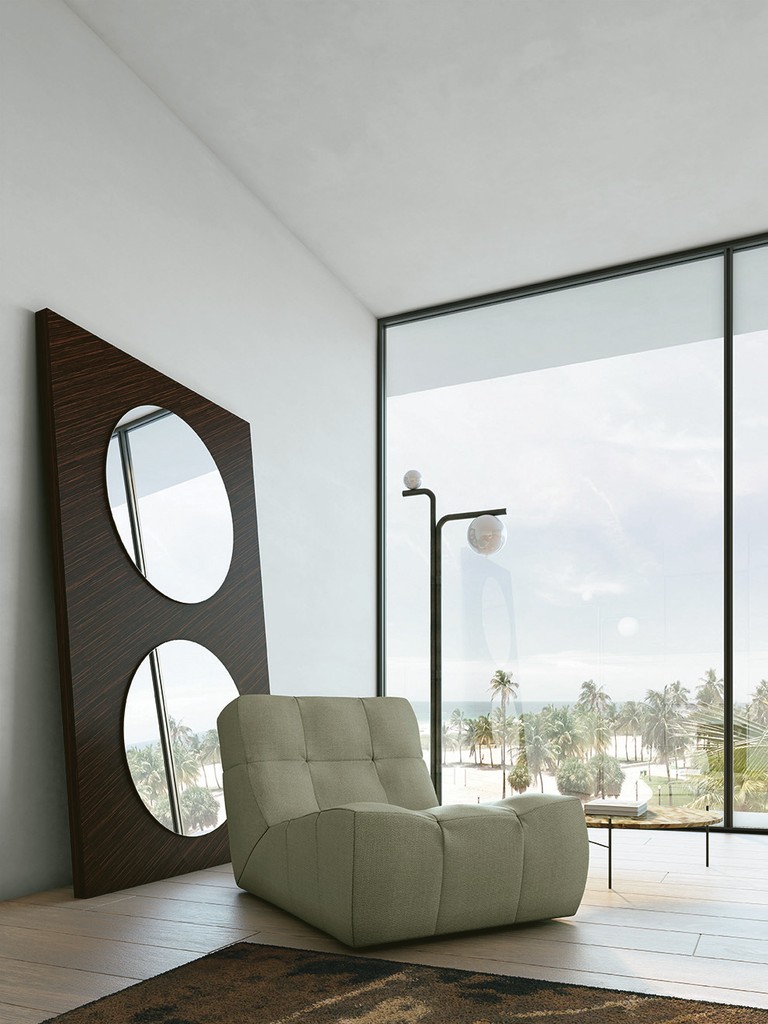 Elegant and soft armchair with stand up mirror and contemporary lighting in a villa at the sea