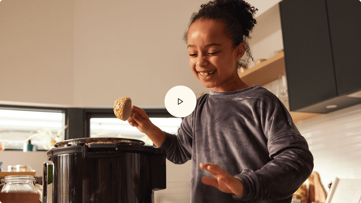 Video thumbnail shows a smiling child holding an ingredient beside a multicooker in a bright kitchen