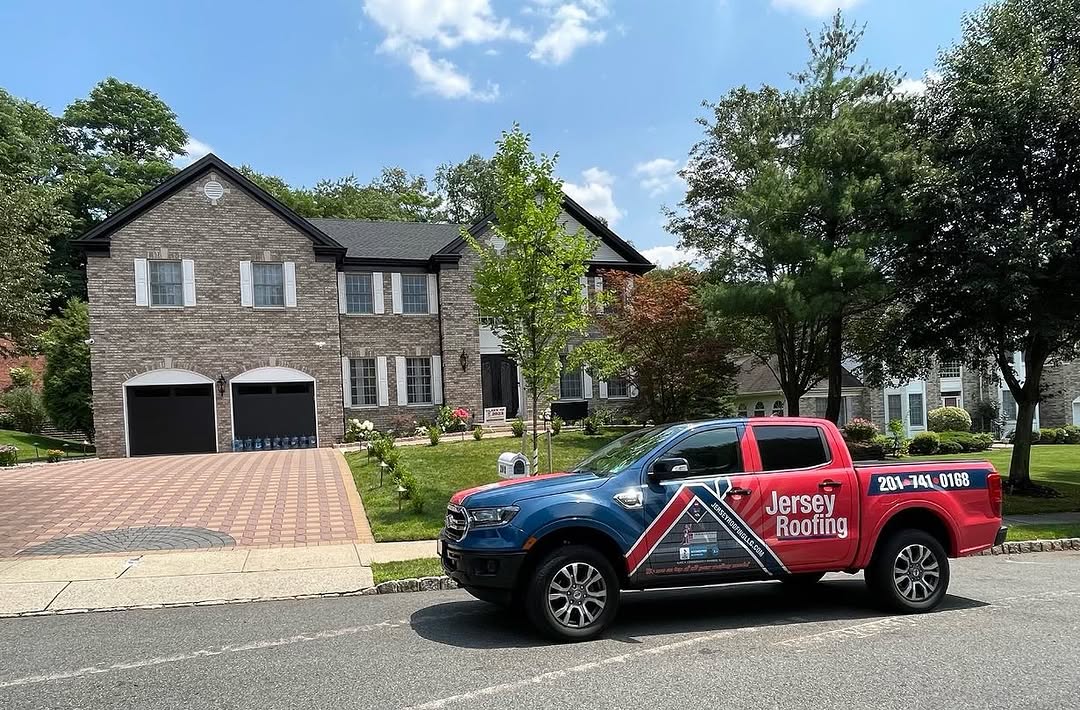 A residential home with a Jersey Roofing truck parked out front