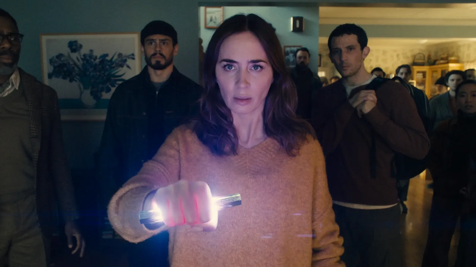 A woman in a cozy living room, holding a bright, glowing flashlight, is surrounded by a group of people attentively focused on her, creating a suspenseful, mysterious atmosphere.