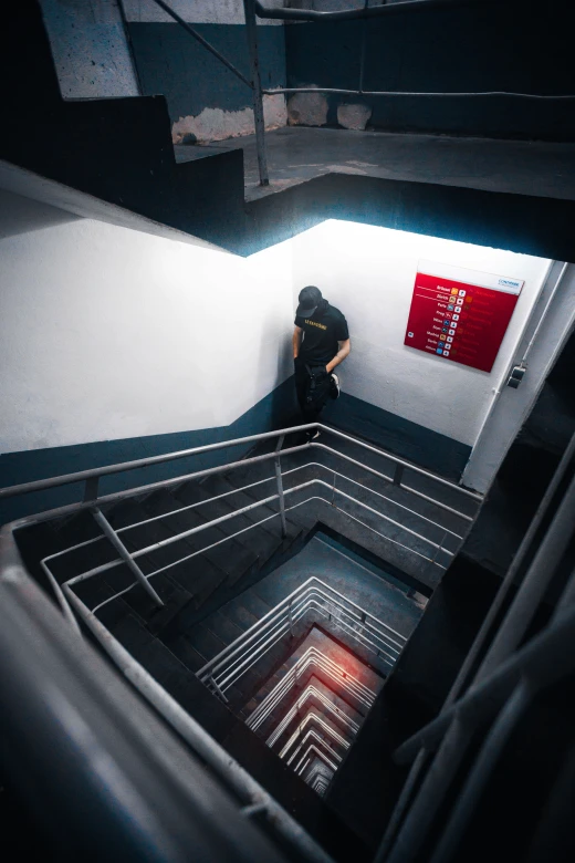 Man leaning on a stairwell lookdown