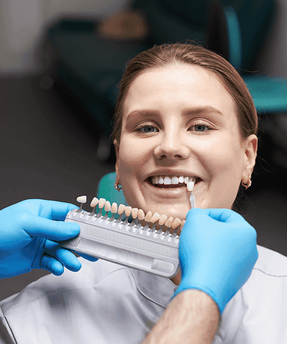 A dental veneers Dubai with an expert cosmetic dentist showing how white the patient’s teeth has become after the treatment.