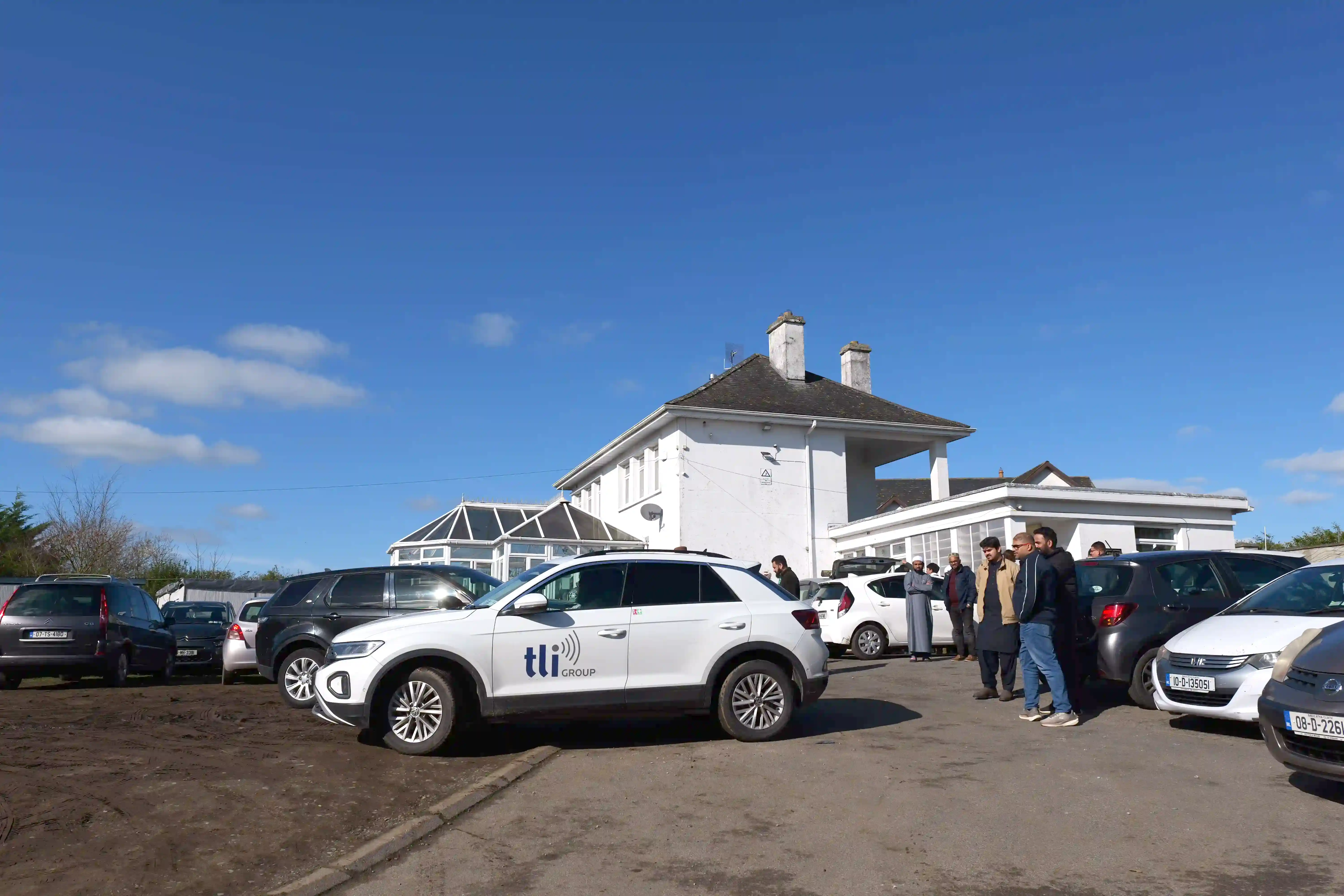 group of women in red and white dress standing on brown wooden bar during daytime