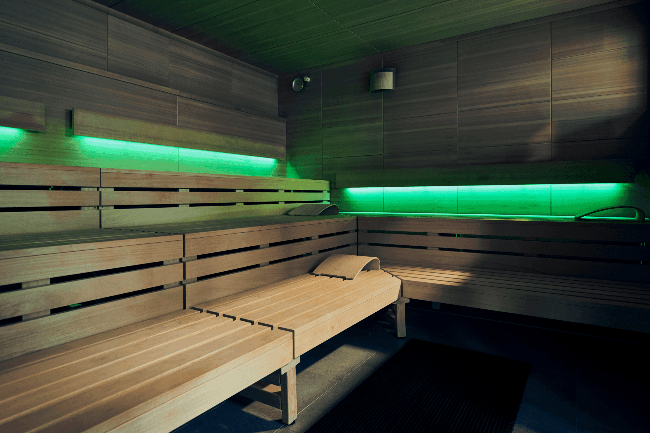 Leere Holzsauna mit grüner Akzentbeleuchtung, moderner Aufbau und entspannender Atmosphäre. Die Sauna ist im XTRAFIT Studio Köln-Marsdorf.