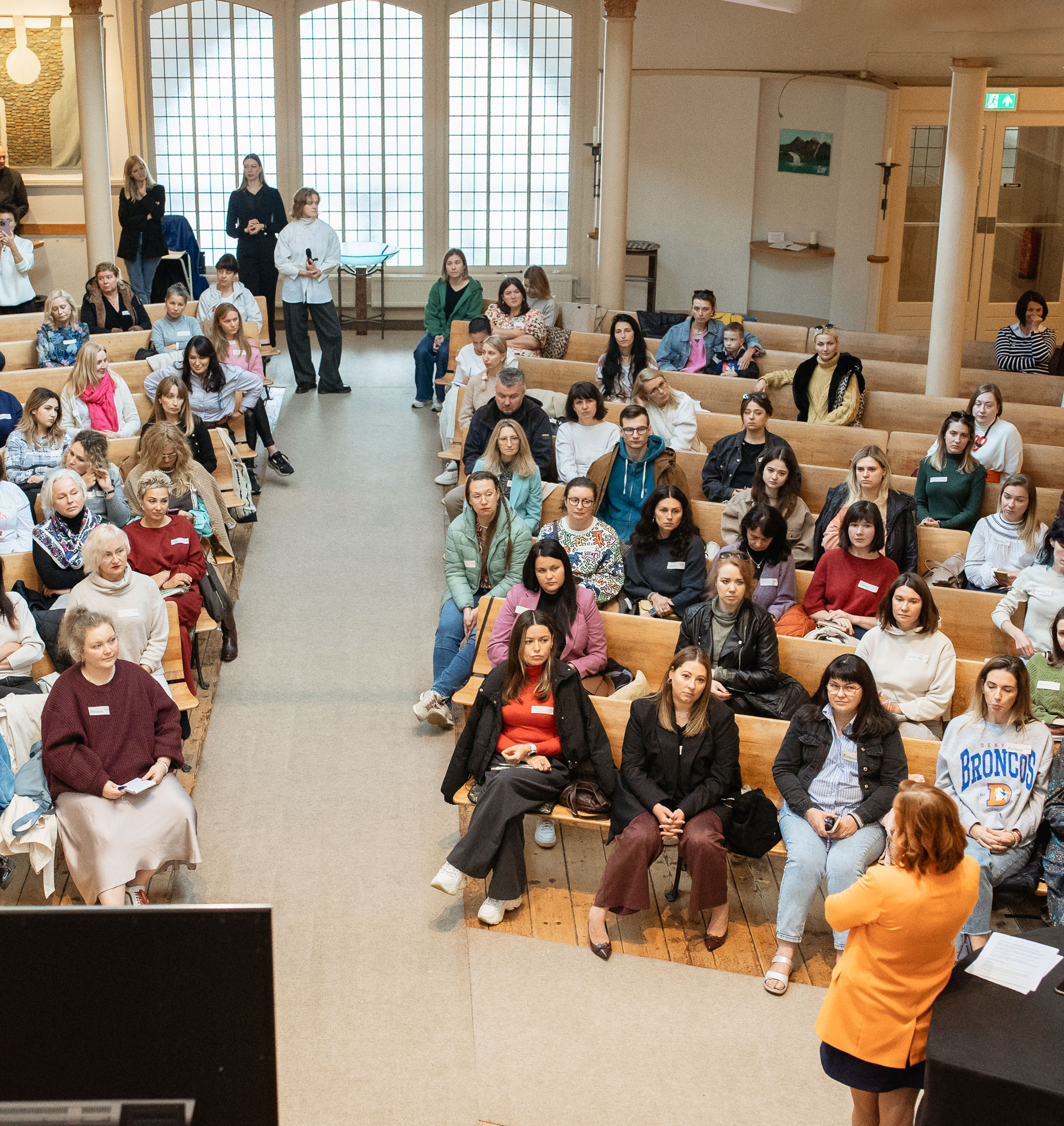 Overhead view of a large group of Ukrainian psychologists attending the Empatia event in a spacious venue, seated in rows and engaging in the program.