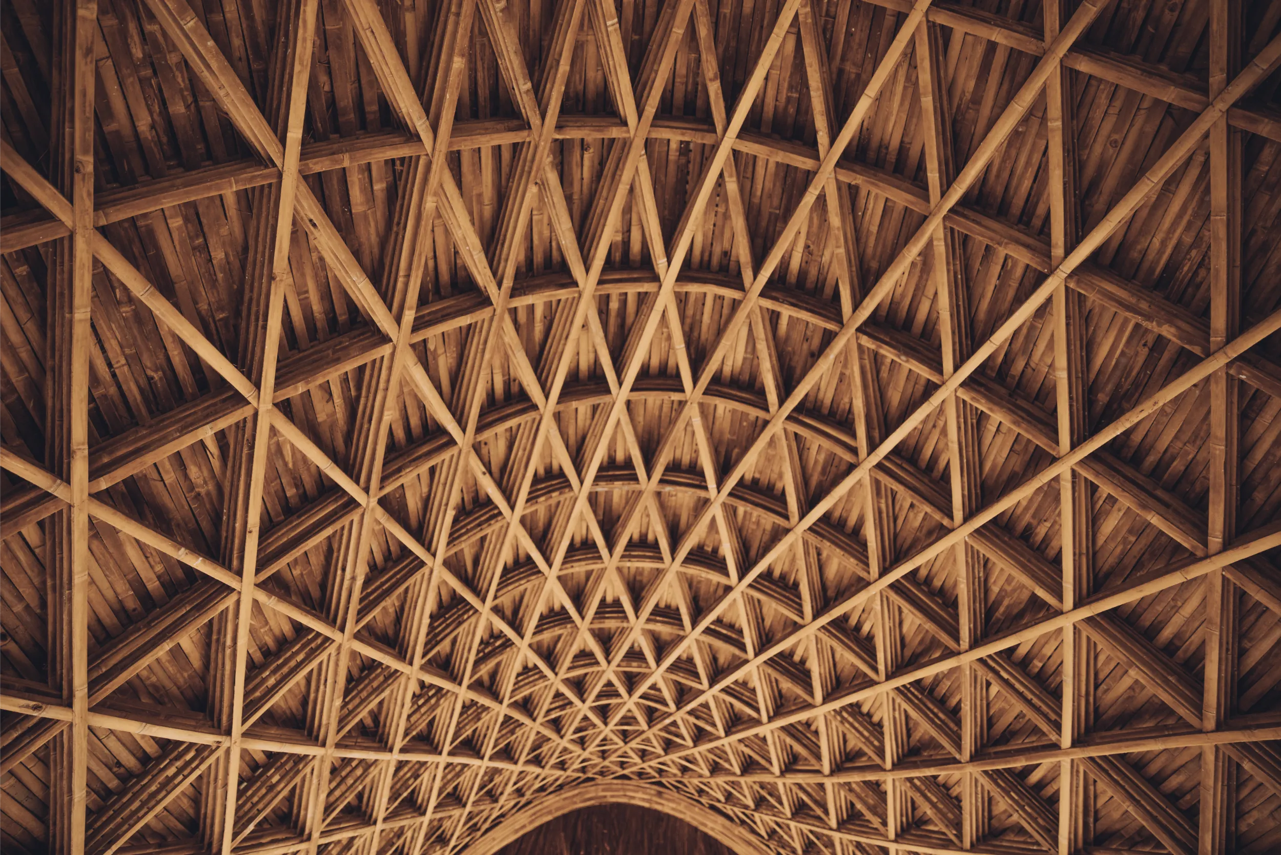 Close-up detail of the complex triangular bamboo weaving geometry that forms the structural shell of the Luum Temple pavilion.