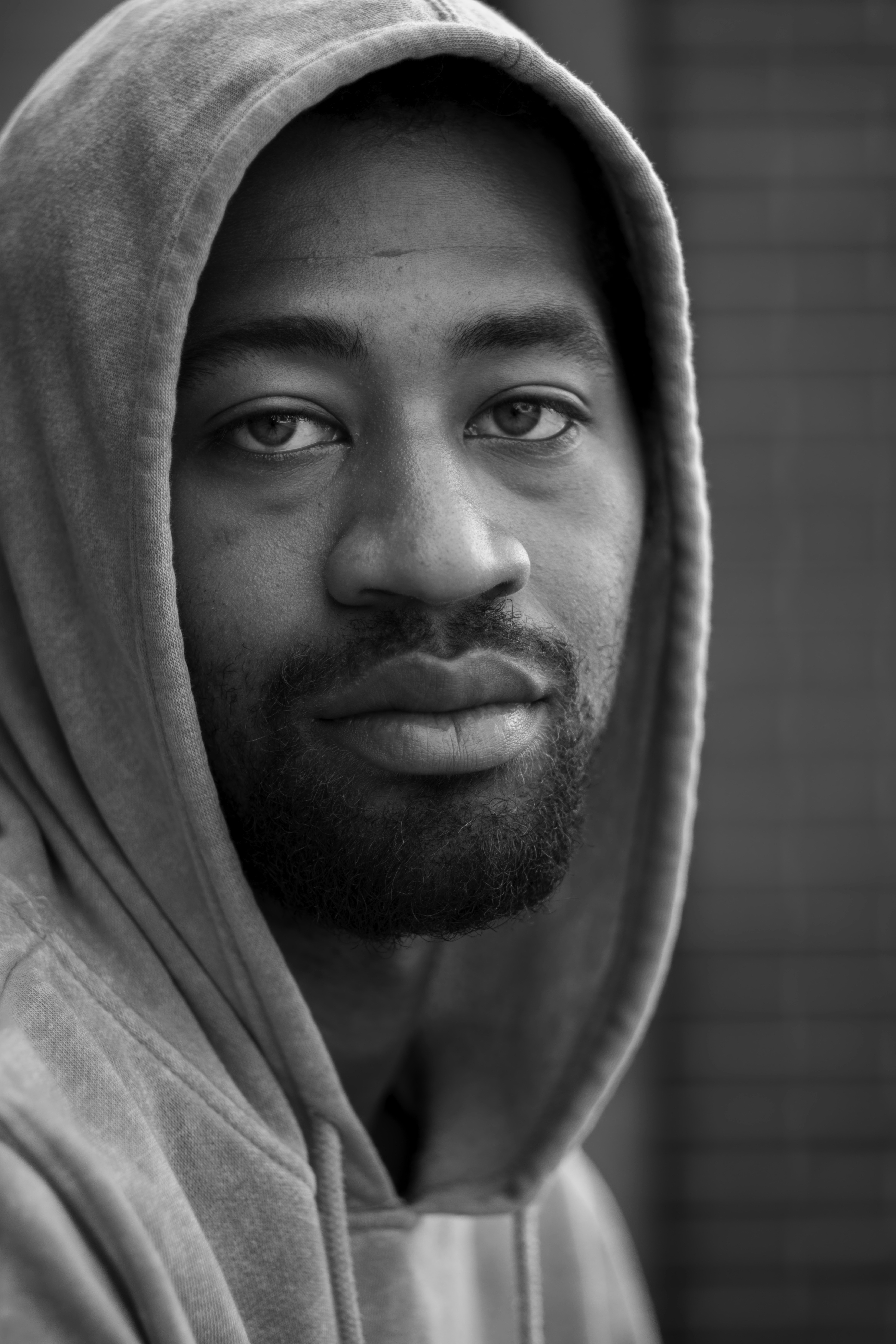 A black and white photo of a man in a hoodie