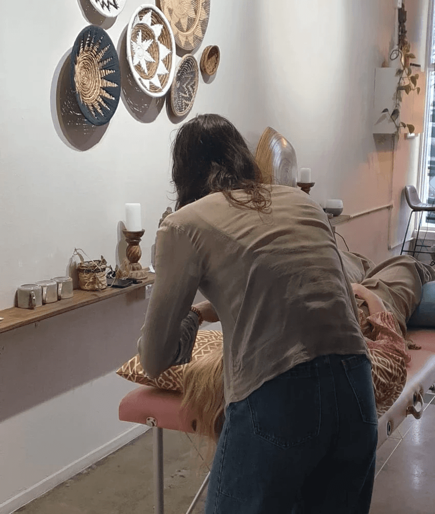 Woman meditates in lotus pose, wearing a rust-colored yoga set.
