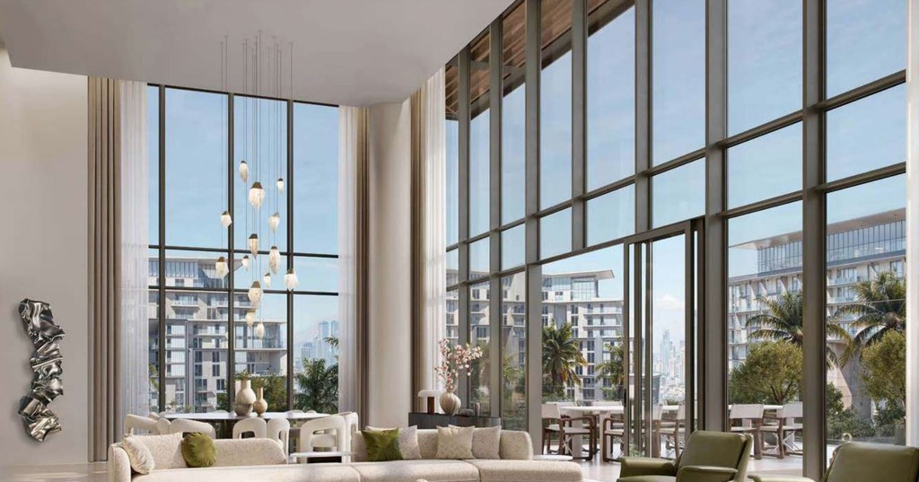 A spacious living room with large windows offering a panoramic view of the city skyline, featuring modern decor.