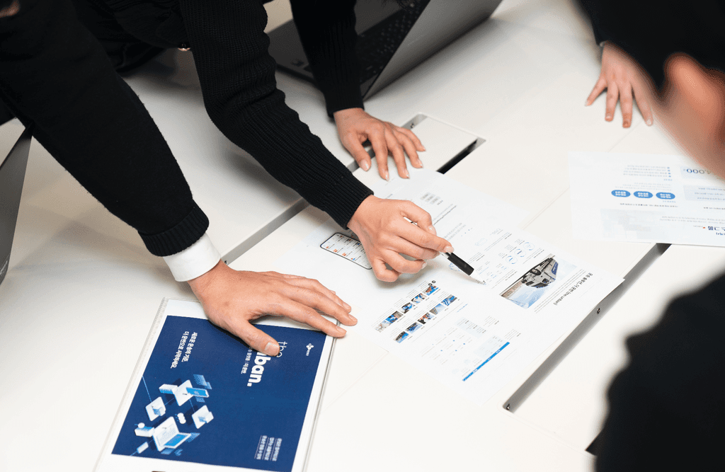 더 운반 운임 최적화 성공 사례를 담은 자료를 여러 담당자가 함께 검토하고 있습니다.