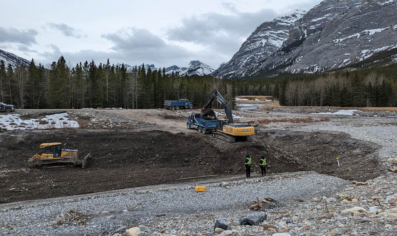 Heavy equipment removing accumulated sediment and debris from Evan Thomas Creek flood mitigation trap